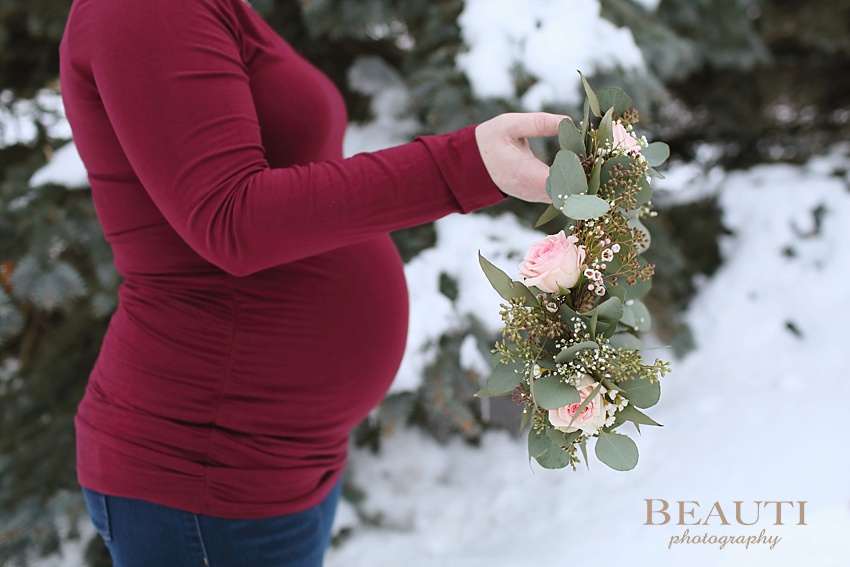 BEAUTI photography Tribune Saskatchewan lifestyle photographer outdoor photography portraits snowy trees session holding floral crown baby belly photo